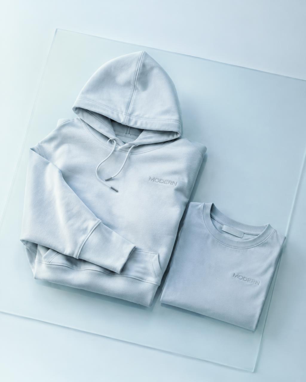 Folded custom hoodie and shirt on frosted glass